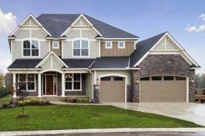 Roof Replacement Dyer IN Single family home with gray shingle roofing, a wide driveway, and a green lawn.